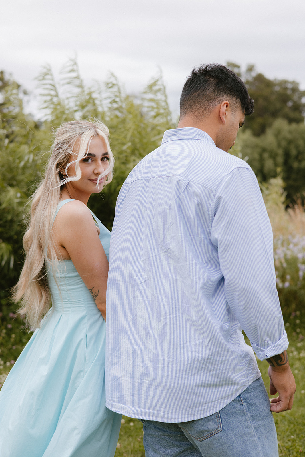 Ellie & Charli walking hand in hand at the esplanade in palmerston north during their engagement photoshoot with lysanah maguire photography