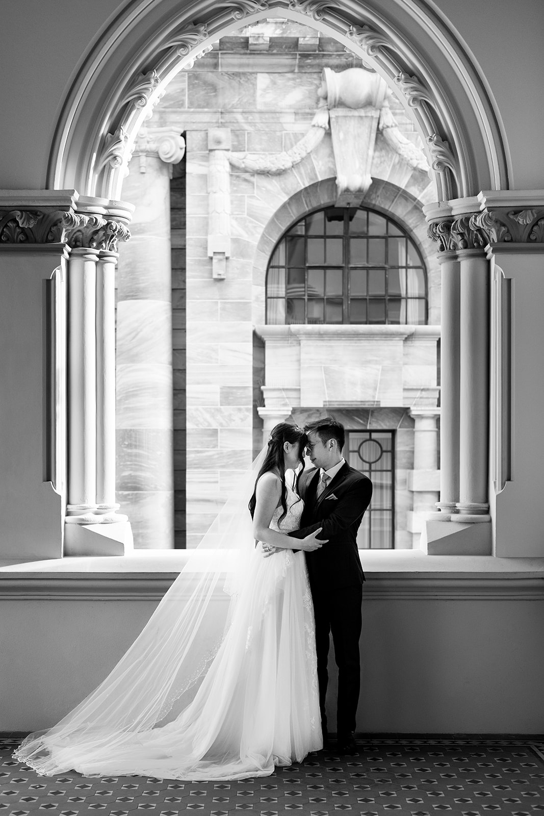 Cornelia and Johnny framed by the architecture of Parliament Library during their Wellington wedding portraits.