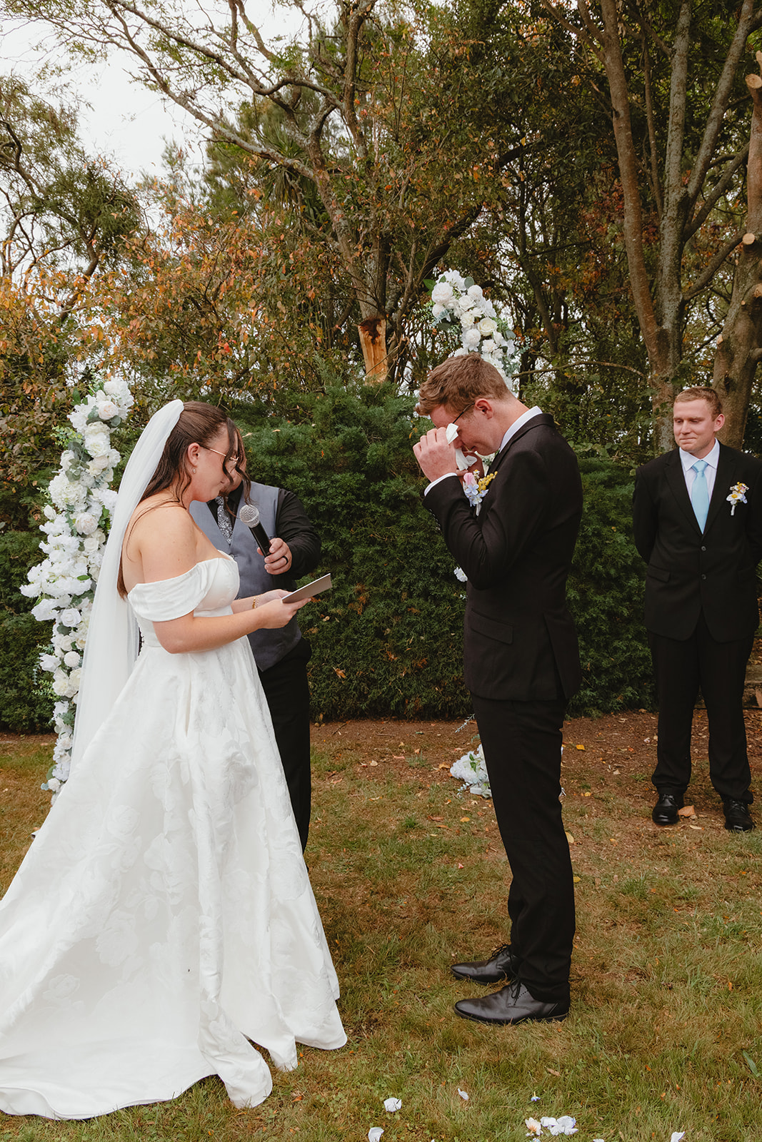 Zoe & Byron exchanging their vows while the groom wipes his tears away, photographed by wellington wedding photographer lysanah maguire during their wedding ceremony