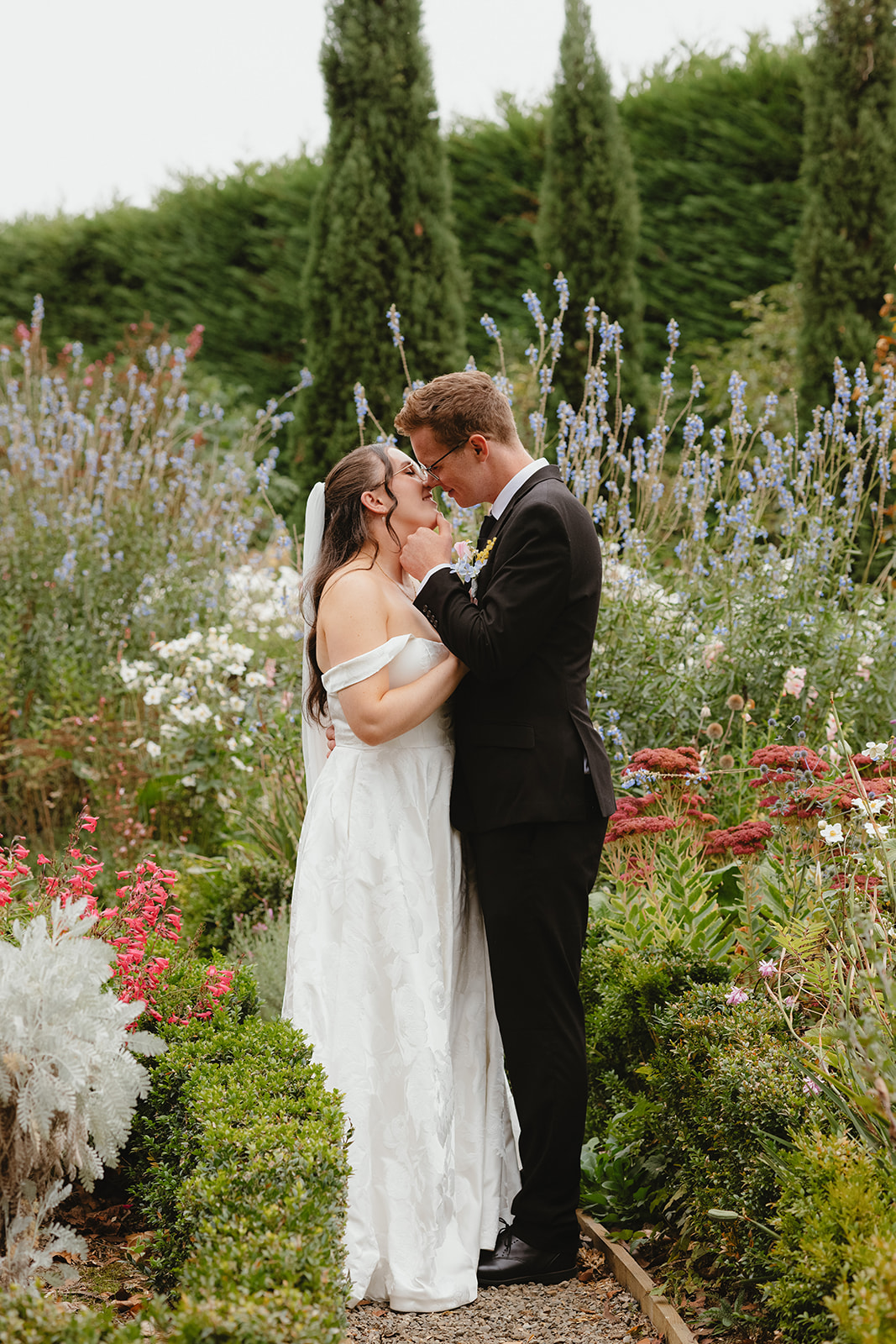 Zoe and Byron embracing in the gardens during their wedding portraits at Villa Candotti.